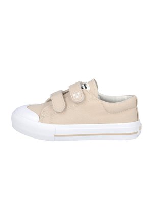Zapatilla de lona beige con dos correas de Velcro, puntera y suela blancas, parte superior texturizada y sutil acento a rayas en la entresuela.