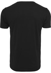 T-shirt noir à manches courtes avec un col rond. Tissu doux et lisse ; sans ornements, sans motifs ni graphiques visibles. Ourlet droit.