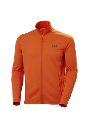 Chaqueta naranja con cremallera y cuello alto, hecha de tejido texturizado. Presenta un logo negro en el lado izquierdo del pecho y un bolsillo lateral con cremallera.