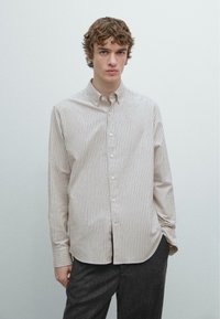 Overhemd met knopen in lichtbeige met verticale strepen in gedempte kleuren. Voorzien van lange mouwen en een klassieke kraag, gemaakt van gladde stof.