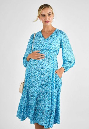 Blauw gebloemde zwangerschapsjurk met V-hals, lange pofmouwen, zijzakken en een tiered zoom. Kenmerkt zich door een patroon van verschillende blauwe verfstreken.