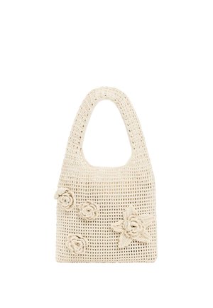 Borsa a crochet color beige con manico arrotondato, motivo a trama aperta e quattro decorazioni a fiore lavorate a crochet sul davanti.