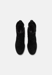 Μαύρες σουέτ μπότες μέχρι τον αστράγαλο με στρογγυλή μύτη, κλείσιμο με φερμουάρ και καουτσούκ σόλα. Εσωτερικά επενδυμένες για άνεση, με μίνιμαλ σχεδιασμό.