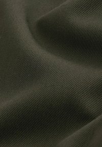 Dunkelolivgrüner, strukturierter Stoff mit einer weichen, glatten Oberfläche, der ein feines Strickmuster aufweist und eine gleichmäßige Oberfläche hat.