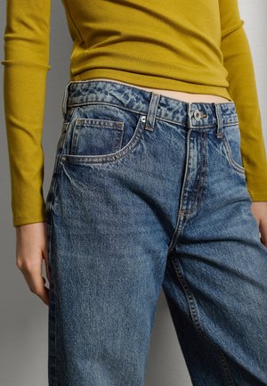 Jeans in denim blu sbiadito con vestibilità comoda, dotati di chiusura con bottone, passanti per cintura e design tradizionale a cinque tasche. Tessuto morbido.