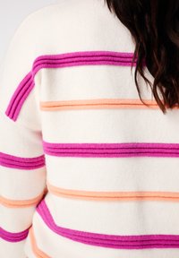 Pull blanc avec des rayures texturées violet, orange et rose. Tissu doux, encolure ronde et détails côtelés ajoutant de la finesse.