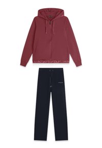 Sudadera con cremallera color burdeos, con capucha, y pantalones de chándal negros con cintura ajustable, detalle de logo y textura de tela suave.