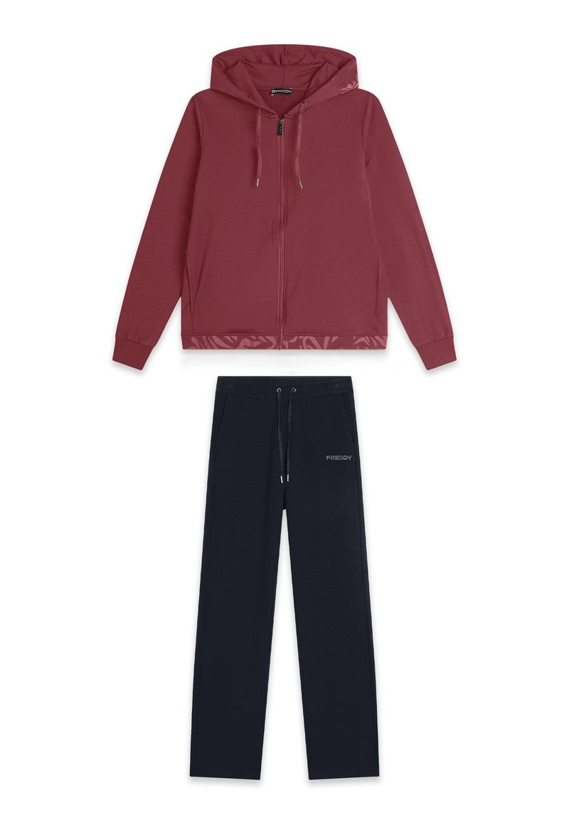 Sudadera con cremallera color burdeos, con capucha, y pantalones de chándal negros con cintura ajustable, detalle de logo y textura de tela suave.