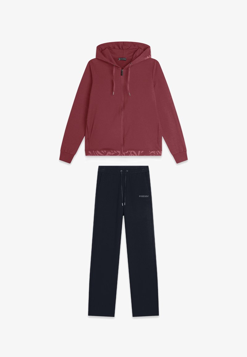 Felpa con zip color bordeaux con cappuccio e pantaloni tuta neri con vita regolabile, dettagli del logo e una texture di tessuto morbido.