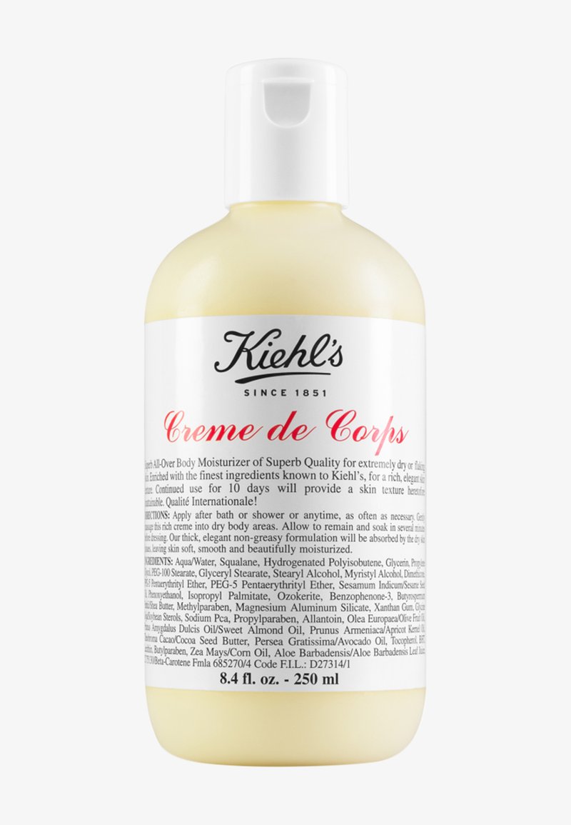 Kiehl's Crème de Corps, 250 ml, genomskinlig flaska med ett vitt pump-lock, har en etikett med svart och röd text som detaljerar ingredienser och instruktioner.