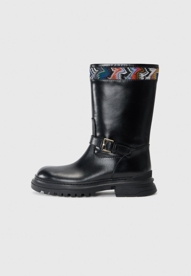 Black leather knee-high boot with a textured multi-colored patterned cuff, gold buckle accent, and rugged black sole.