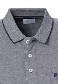 Blauw-wit geblokte polo met kraag, voorzien van drie knopen en een borstzak met een logo. De stof is geweven.