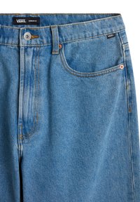 Jean Vans en denim bleu avec fermeture par bouton, poche avant droite, passants pour ceinture et étiquettes de marque visibles sur la taille et la poche.