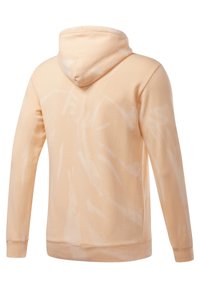 Sweat à capuche de couleur pêche, en coton, coupe décontractée, avec un motif tie-dye abstrait blanc. Dispose d'une capuche avec cordon de serrage et de poignets côtelés.