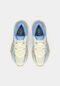 Παπούτσια τρεξίματος Asics με σχέδιο από δίχτυ, σε απαλούς μπλε και κρέμα χρωματισμούς. Υφή στο επάνω μέρος με οπές και κρέμα κορδόνια. Φωτεινός χρωματισμός σόλας.