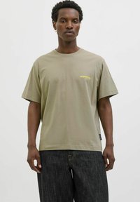 Olivengrøn t-shirt i blødt bomuld med korte ærmer og rund hals. Lille gult 'project core' logo på venstre bryst.