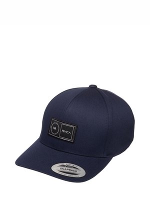 Ciemnoniebieska czapka snapback z płaskim daszkiem, czarna prostokątna naszywka z logo RVCA oraz srebrną naklejką na daszku.
