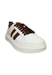 Sneaker bianco in pelle con accenti e lacci marroni, caratterizzato da una punta arrotondata, suola in gomma e dettagli cuciti. Nome del marchio visibile.