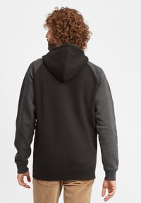 Bluza z kapturem w czarnym kolorze z szarymi rękawami raglanowymi. Posiada miękki materiał, kieszeń kangurzą oraz ściągacze przy mankietach i dolnym brzegu.