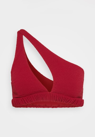 Red one-shoulder bikini top made of textured fabric with a gathered hem. Features a cutout design on the side, creating asymmetrical lines.