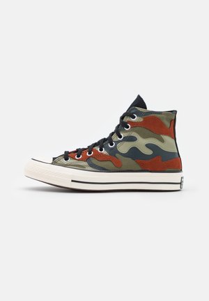 Hoge sneakers met een meerkleurig camouflagepatroon in groen, bruin en zwart. Voorzien van witte rubberen zolen en klassieke zwarte veters.