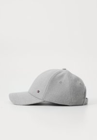 Grå uld baseballcap med en buet skygge, der har diskrete logo-detaljer på fronten og metaløjer til ventilation.