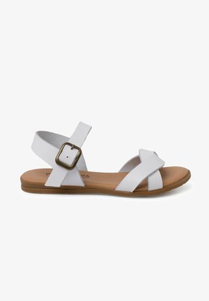 Sandales en cuir blanc avec des brides croisées et un détail de boucle. Semelle plate avec un pied en brun. Design ouvert pour la respirabilité.