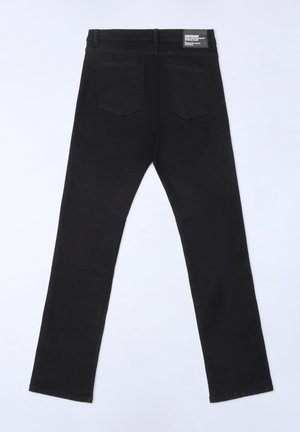 Sorte denim jeans med slim fit, fem lommer, bæltestropper og et mærke på den bageste talje, vist bagfra.