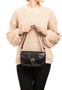 Zwarte leren handtas met een gestructureerde vorm, voorzien van een sluiting met gesp en een korte strap. Het oppervlak heeft een gladde textuur en stikseldetails.