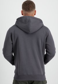 Felpa con cappuccio grigio scuro in tessuto morbido, dotata di un cappuccio ampio, maniche lunghe e polsini e orlo a costine. Design semplice e funzionale.