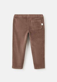Pantaloni din corduroy maro, cu o țesătură texturată, talie elastică și un singur buzunar la spate cu un mic etichetă logo.