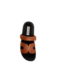 Brown leren slide sandaal met twee verstelbare banden en een uitsnede ontwerp. Zwarte zool met een vlak profiel. Steve Madden-merk aanwezig.