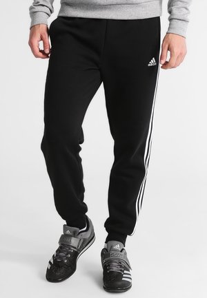 Zwarte joggingbroek met witte zijstrepen, gemaakt van zacht stof. Voorzien van een elastische tailleband en een slanke pasvorm voor comfort.