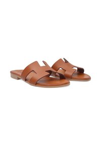 Bruine leren sandalen met een uitgesneden ontwerp, platte zool en open teen. Casual stijl met een soepele textuur en minimale accenten.