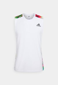 Biała bezrękawnik sportowy z akcentami w kwiatowy wzór na ramionach i bokach. Z przodu znajduje się czarne logo adidas.