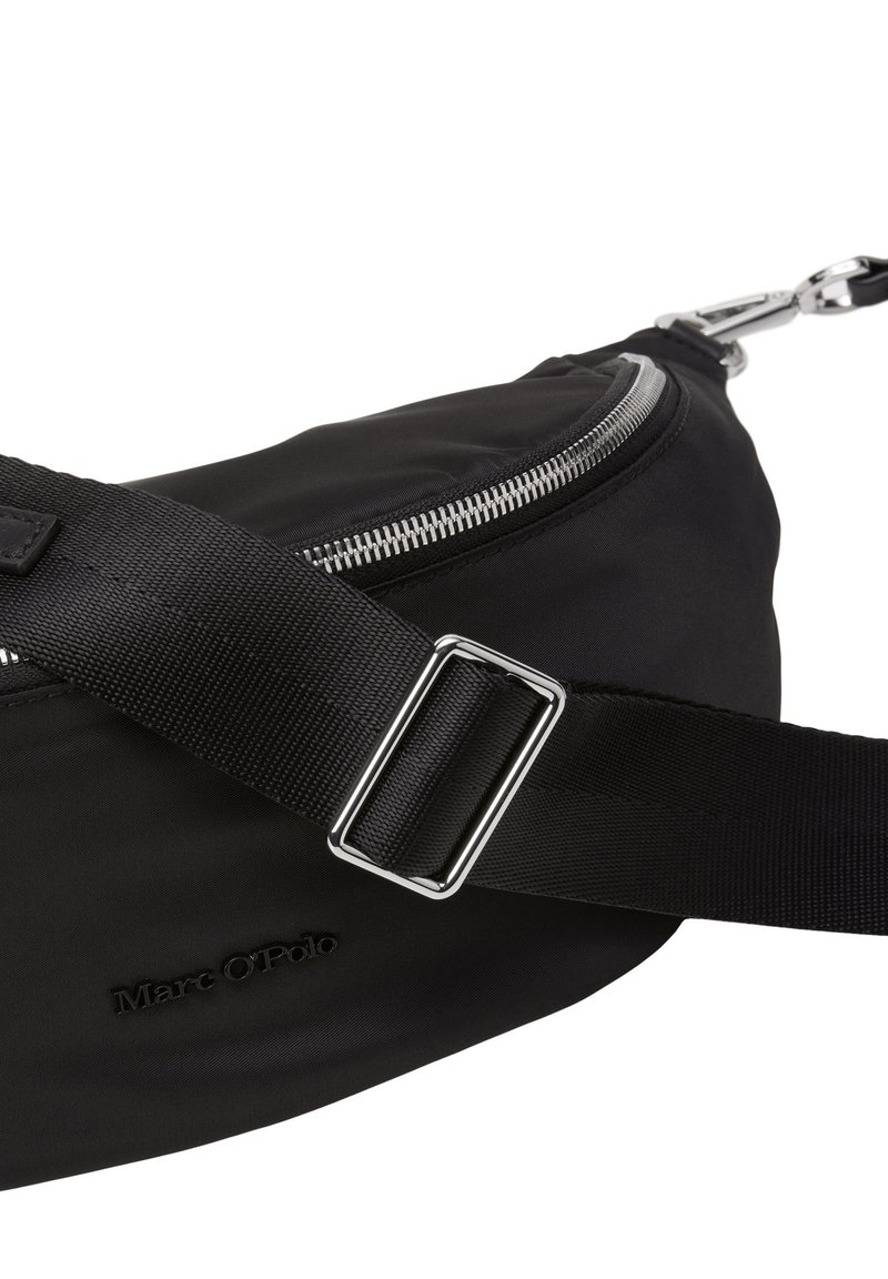 Czarna nylonowa saszetka na biodra o zakrzywionym kształcie, z metalowym suwakiem, regulowanym paskiem i wytłoczonym logo w dolnej części. Wytrzymała konstrukcja.
