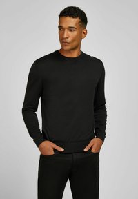 Zwarte gebreide trui met een ronde hals, lange mouwen en ribgebreide manchetten. Gladde textuur, aansluitend ontwerp en minimalistische stijl.
