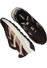 Brown mesh sneakers with black leather accents and cream rubber soles. Features a prominent logo and textured upper design.