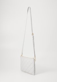 Bolsa transversal matelassé cinza claro com ferragens douradas, design plano, alça ajustável, fecho de zíper e textura de couro suave.