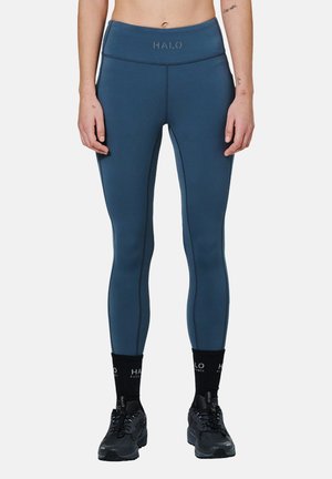 Legginsy z wysokim stanem w ciemnoniebieskim kolorze z kontrastowymi szwami. Miękka tkanina, dopasowany krój i logo HALO na pasku. Odpowiednie do noszenia w trakcie aktywności fizycznej.