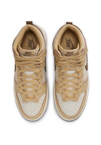 Beige kožené vysoké tenisky Nike s bílými akcenty, texturovanou tkaninou uvnitř, výrazným šněrováním a perforovanou špičkou pro prodyšnost.