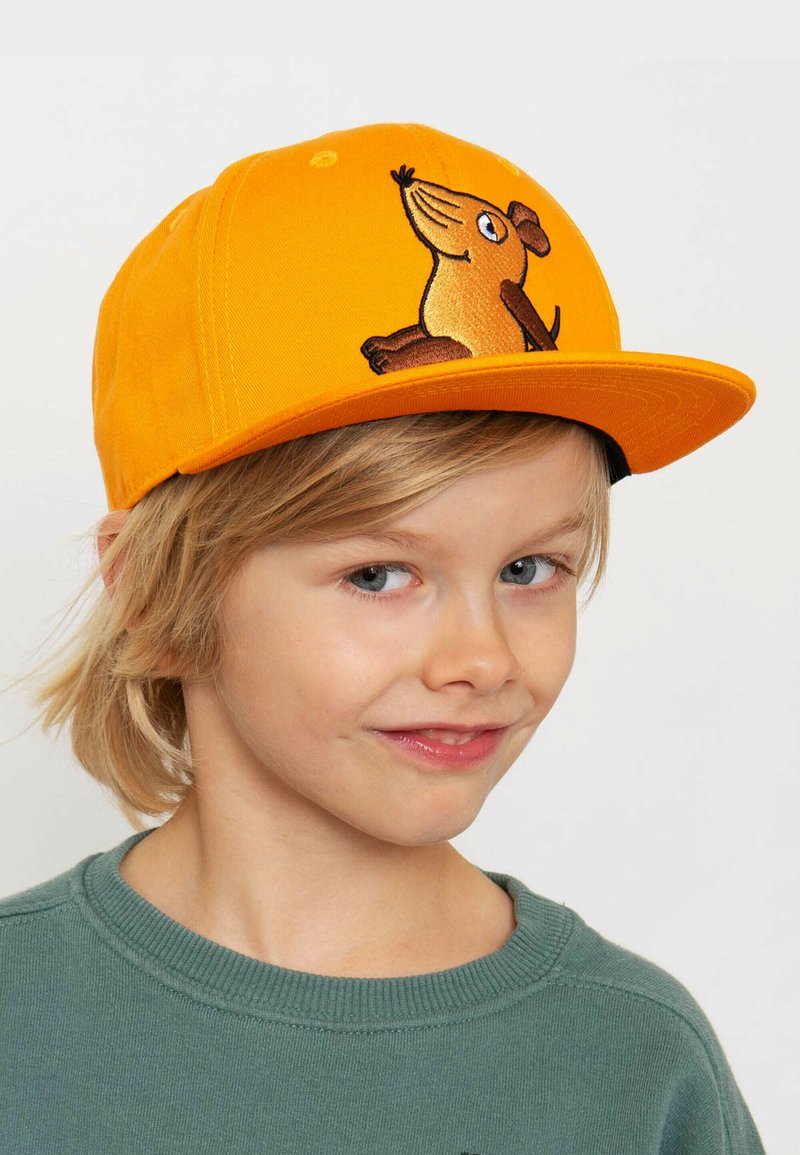 Gelbe Kappe aus Stoff mit strukturiertem Design. Auf der Vorderseite befindet sich eine gestickte braune Hundillustration.