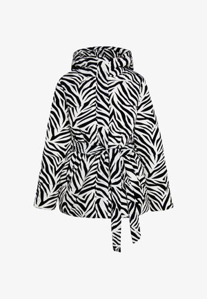 Veste matelassée zèbre en noir et blanc, dotée d'une capuche, d'une taille ceinturée et d'une texture matelassée avec des rayures prononcées.