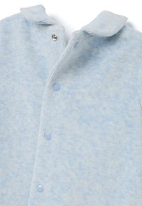 Cárdigan azul claro con una tela suave y texturizada. Presenta un cuello con solapa, cierre de botones a presión y un patrón tenue.