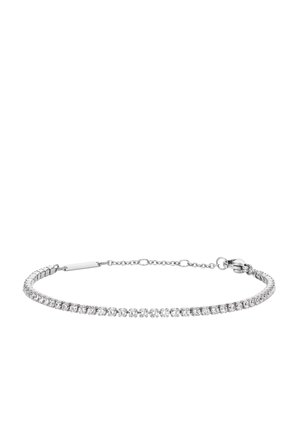 Bracelet de tennis en argent avec petites pierres claires taillées rondes et fermoir sécurisé à fermeture mousqueton sur fond blanc.