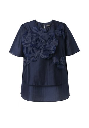 Blusa de manga corta azul marino con tela en capas y gran aplicación floral en la parte delantera, escote redondeado y dobladillo ligeramente desigual.