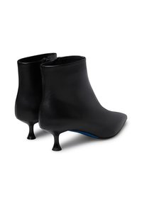 Stivali in pelle nera alla caviglia con punta affilata, gambale corto e tacco curvo distintivo. Presentano una cerniera e accenti blu all'interno.