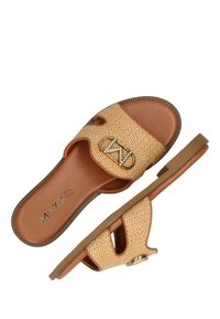 Jasnobrązowe plecione klapki z otwartym noskiem i złotym akcentem logo. Płaska podeszwa o delikatnej ryflowanej fakturze zapewniającej przyczepność.