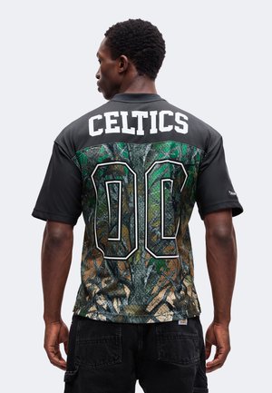 Mężczyzna widziany od tyłu, ubrany w czarny i kamuflażowy jersey Celtics z nadrukowanym numerem 00 na plecach.