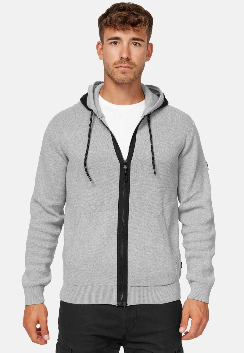 Grijze hoodie met rits en een zwarte voering in de capuchon, voorzakken en een contrasterende zwarte rits. Heeft verstelbare trekkoorden en geribde manchetten.